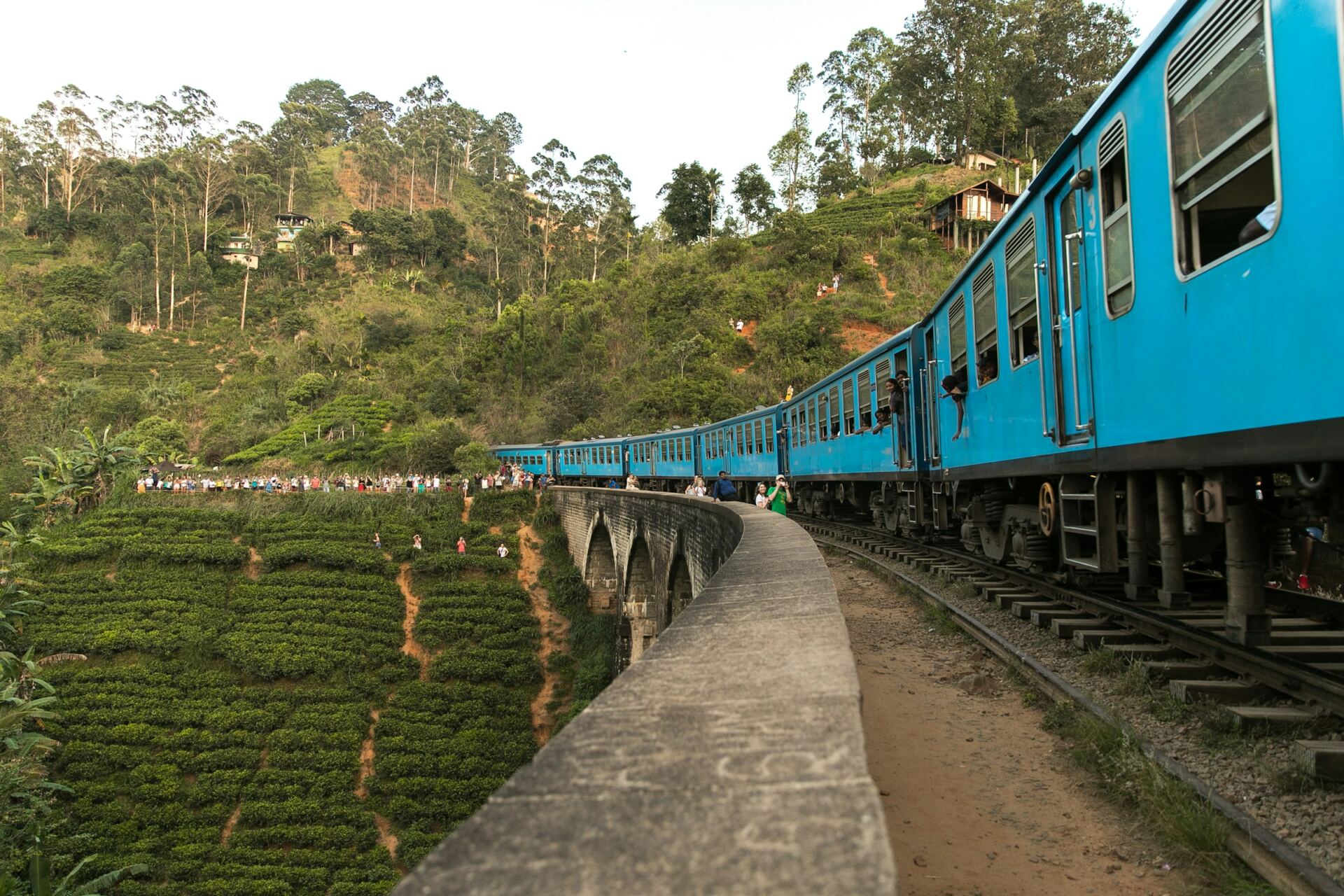 A blue train crossing Nine Arch Bridge in Ella, Sri Lanka